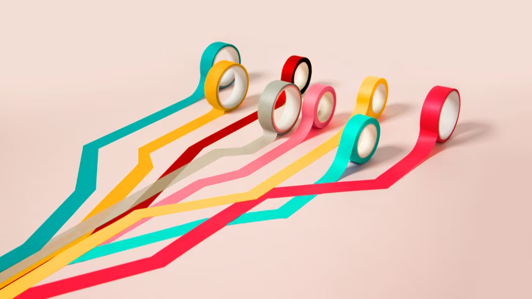 Múltiples hebras de cinta de colores uniéndose.